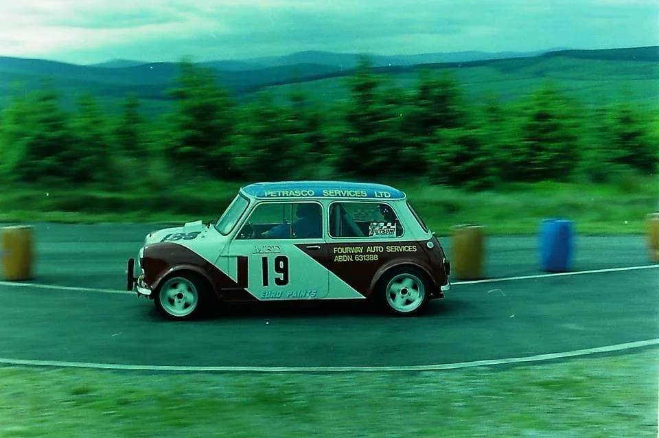 Classic Mini number 19 cornering on highland rally stage